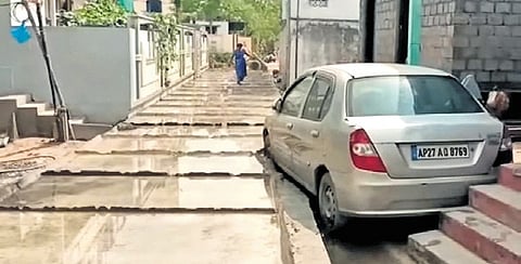 A cement road was constructed without moving a car parked in front of a house in Amodagiripatnam at Vetalapalem Mandal of Bapatla District. 