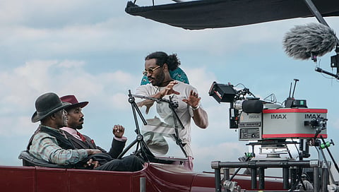 This image released by Warner Bros. Pictures shows actors Delroy Lindo, from left, and Michael B. Jordan with director-writer-producer Ryan Coogler on the set of "Sinners."