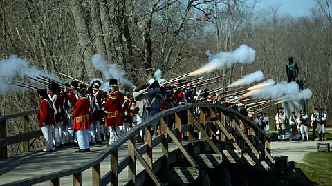 Acton Minutemen and British soldiers fire a ceremonial volley from the North Bridge, after the re-enactment of the North Bridge fight marking the 241st anniversary of the start of the American Revolutionary War, Monday, April 18, 2016, in Concord, Mass. 