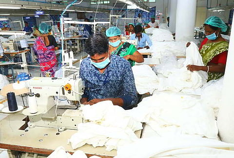 Knitwear workers are working at a private knitwear company located near Periyar Colony in Tiruppur, 