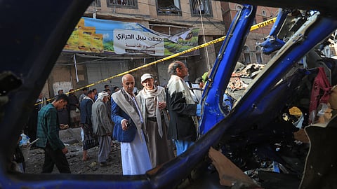 People assess the damage caused by a US airstrike in a neighbourhood in the Huthi-controlled Yemeni capital Sanaa on April 21, 2025. 