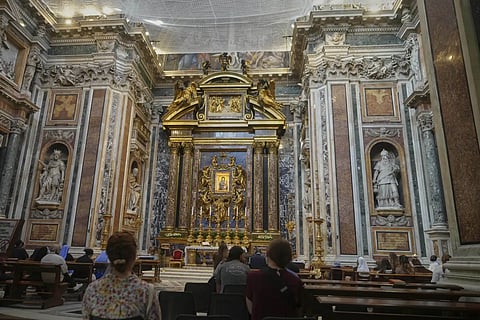 Faithful pray before the Salus populi  Romani (Salvation of the people of Rome), a Byzantine-style painting that features an image of Mary, draped in blue robe, holding the infant Jesus who in turn is holding a jeweled golden book, inside St Mary Major basilica, where Pope Francis will be buried, in Rome, Tuesday, April 22, 2025.