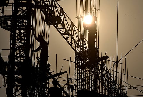 Contruction workers  seen like holding sun as they work on a  construction site during hot sun today at Bhubaneswar.