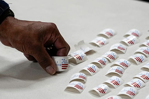 A voter picks up a sticker after voting at a polling place, March 5, 2024, in Nashville, Tenn.