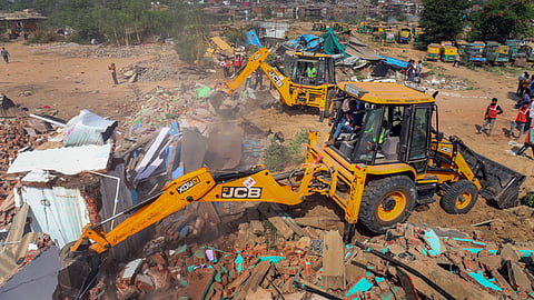 Backhoe loaders being used by the Amdavad Municipal Corporation (AMC) during a demolition drive near Chandola lake, in Ahmedabad, Tuesday, April 29, 2025. 