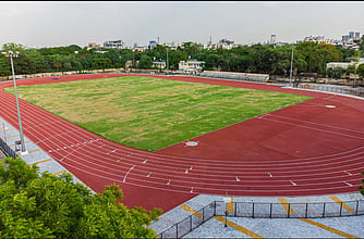 Madras High Court has temporarily stayed the award of tender and work order issuance by the police department to a private firm for laying synthetic tracks.
