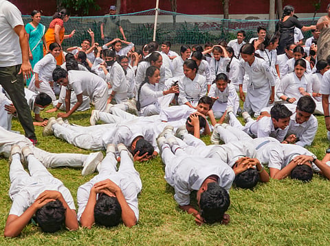 School students take part in a drill as part of a nationwide civil defence drill, in New Delhi, Wednesday, May 7, 2025.