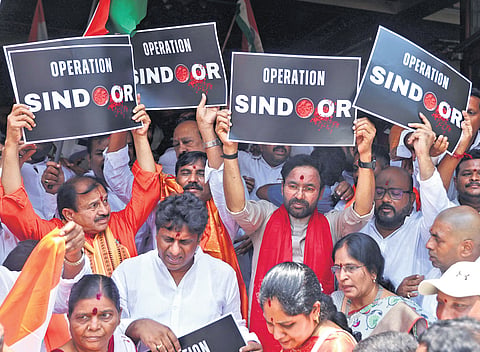 Union Minister G Kishan Reddy holds a placard after offering prayers at Kanakadurga temple for the soldiers’ on Saturday 