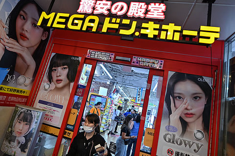 This photo taken on April 21, 2025 shows a woman leaving a branch of Japanese discount retailer Don Quijote, also known overseas as Don Don Donki, in the Shibuya district of central Tokyo. 