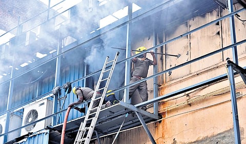 Heavy smoke emanating from inside the building as fire and rescue personnel attempt to douse the fire at a textile showroom in Chennai on Monday 