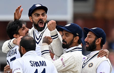 (FILE PIC) Virat Kohli (3L) and Cheteshwar Pujara (R) after the successful appeal for the wicket of England's Jonny Bairstow on the fifth and final day of the second Test match between England and India at Lord's cricket ground in London on August 16, 2021. 