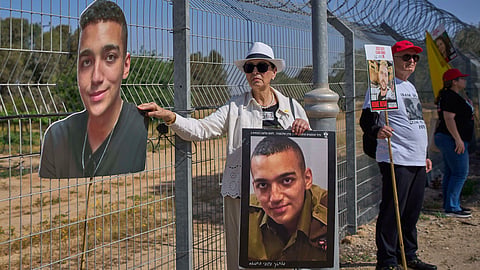 Varda Ben Baruch holds a picture of her grandson Edan Alexander, who is held hostage in Gaza, gathers with other families to call out on loudspeakers in hopes that their loved ones will hear them, near the Gaza border in Kibbutz Nir Oz, southern Israel, April 20, 2025. 