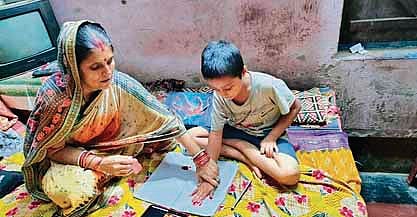 A student completing his assignment with the help of his mother