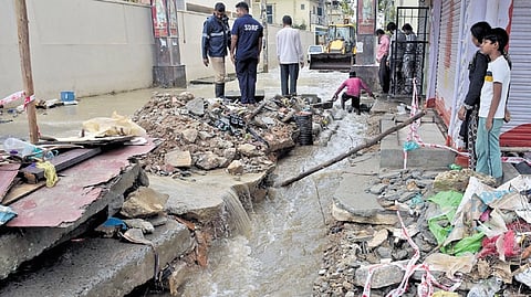 BBMP workers make a channel for rainwater to flow at Sai Layout on Tuesday. 