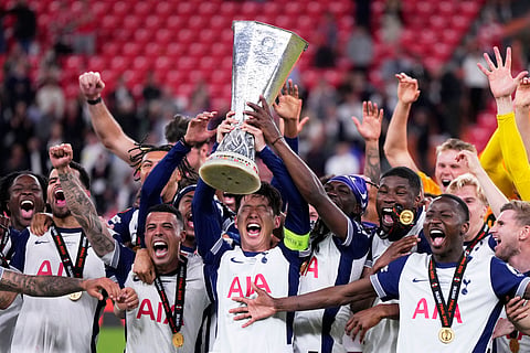 Tottenham's Son Heung-min holds the trophy aloft as he celebrates with teammates after winning the Europa League final soccer match against Manchester United at the San Mames Stadium in Bilbao, Spain, Wednesday, May 21, 2025. 