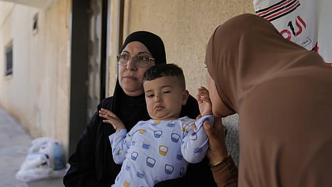 Palestinian Hazar Estity kisses her 21-month-old son, Nizar, who is being held by his grandmother, Nazek, on April 29, 2025, at an apartment in the West Bank town of Zababdeh. Estity says she was used as a human shield by Israeli soldiers. 