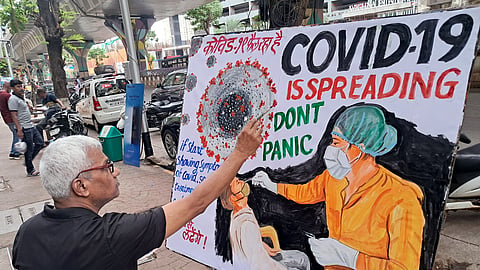 In this photo from May 21, 2025, a teacher of Gurukul School of Art makes an awareness painting of COVID-19, in Mumbai. 