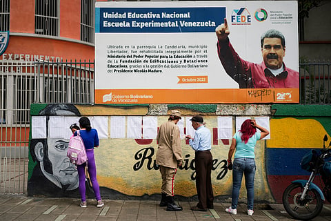 Voters look at the rolls at a polling station during legislative and local elections in Caracas, Venezuela, Sunday, May 25, 2025.