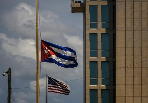 A Cuban flag is seen next to an American flag outside the U.S. embassy in Havana, Cuba, May 17, 2022. 