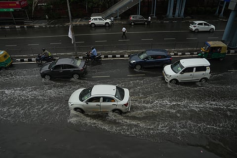 Vehicles move through a waterlogged road following rains, at ITO in New Delhi, Sunday, May 25, 2025.