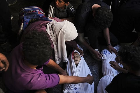 Mourners gather around the body of Palestinian child Ghazwane Hamdan,10, killed in an  Israeli army airstrike, and brought to the Baptist Hospital  in Gaza City, Monday, May 26, 2025.