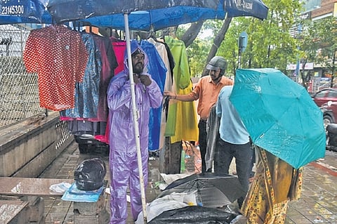 As monsoon sets in, a rain coat and umbrella vendor makes brisk business, in Bengaluru on Wednesday 