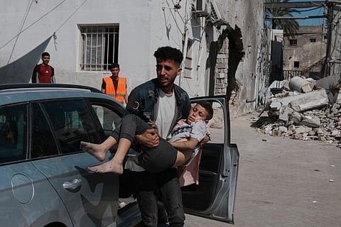 A Palestinian boy, injured following an Israeli airstrike, is brought for treatment to the Baptist Hospital in Gaza City, Friday.