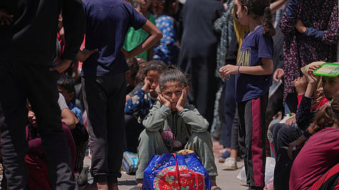 A Palestinian girl waits to collect donated food at a food distribution kitchen in Deir al-Balah, Gaza Strip, Friday, May 30, 2025.