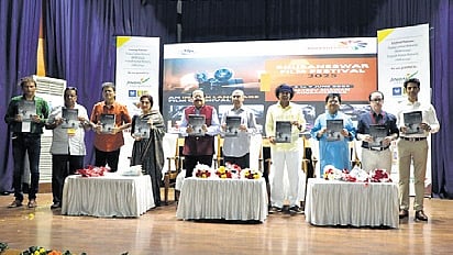 Chief guests and attendees post with the newly released book 'Moods and Madness - In Memoriam' at the event. 