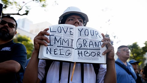 A protester holds up a message handwritten inside a Bible during a demonstration in response to a series of US Immigration and Customs Enforcement (ICE) raids throughout the country, Tuesday, June 10, 2025, in Los Angeles. 