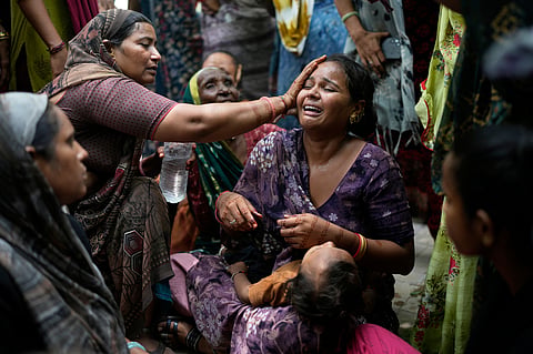 A relative of a victim of the Air India plane crash is comforted as she breaks down at a hospital in Ahmedabad, India, Friday, June 13, 2025. 