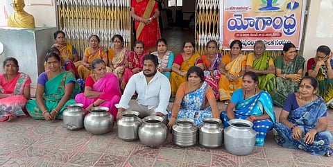 The residents of Parvathipuram town staging protest with empty bins at municipal office demanding for drinking water supply.