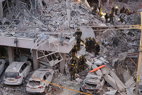 Responders work amid building rubble following a strike by an Iranian missile in the Israeli city of Bat Yam, south of Tel Aviv, early on June 15, 2025. Air raid sirens and booms rang out in Jerusalem and Tel Aviv early on June 15, AFP journalists said, as Israel and Iran exchanged fire for a third day.