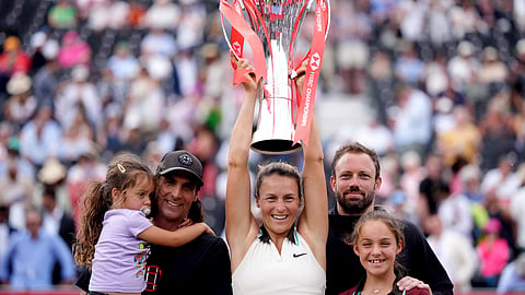 Tatjana Maria of Germany holds the trophy as she celebrates with her family after winning