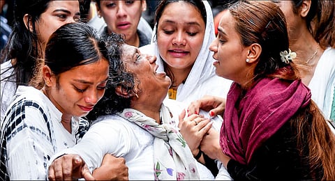 Mother of Saineeta Chakravarty, a cabin crew member and among the victims of the Air India plane crash, mourns after her mortal remains were brought home, at Juhu, Mumbai, Monday, June 16, 2025. 