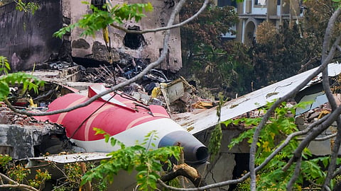 A crane removing aeroplane's tail from the wreckage after the June 12 Air India flight 171 crash, is pictured in a residential area near the airport in Ahmedabad on June 14, 2025.