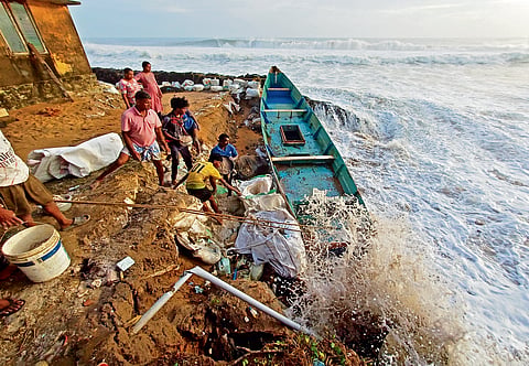 Fisherfolk at Kannanthura attempt to save their homes and shoreline by stacking sandbags and unused fishing boats