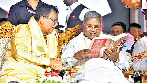 CM Siddaramaiah and Minister KN Rajanna share a light moment at a programme to mark the latter’s 75th birthday, in Tumakuru on Saturday