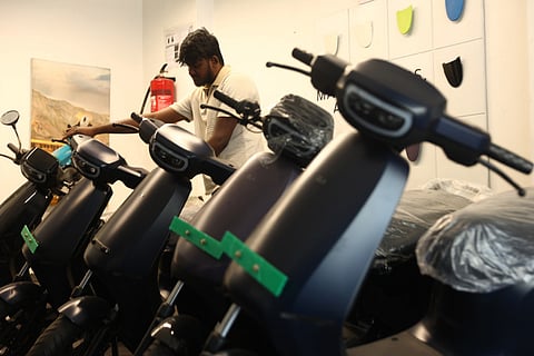 A man looks at electric scooters at an outlet in Hyderabad. 