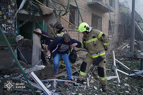 This handout photograph taken and released by Ukrainian State Emergency Service on June 23, 2025 shows rescuers evacuating local residents from the damaged building following night Russian drone and missile strikes in Kyiv, amid Russian invasion in Ukraine. 