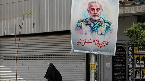 An Iranian woman walks past a banner showing head of the paramilitary Revolutionary Guard's Khatam al-Anbiya Central Headquarters Gen. Gholam Ali Rashid, who was killed in Israeli strike, at Enqelab-e-Eslami (Islamic Revolution) street in downtown Tehran, Iran, Tuesday, June 24, 2025