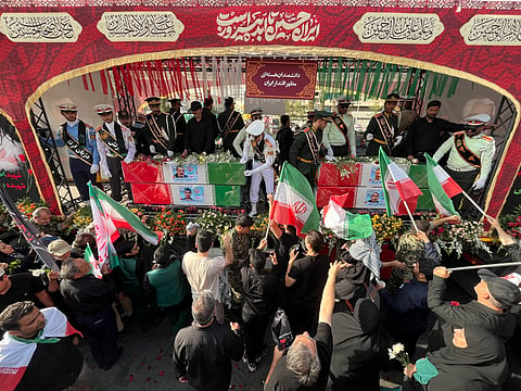 People mourn over the flag-draped coffins of Iranian nuclear scientists who were killed in Israeli strikes, during a funeral ceremony in Tehran. Iran, Saturday, June 28, 2025. 