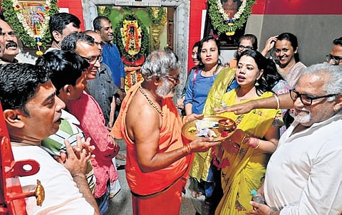 Residents of Holiday Village Road perform puja on Sunday, hoping that their prayers for road restoration will be answered soon 