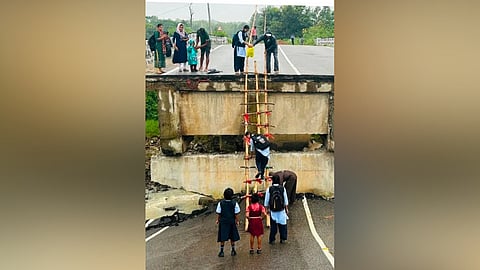 Children studying in Catherine School have to take the challenge of scaling the 25-foot ladder every day to reach their school after the Pelol bridge collapsed after  incessant rains.