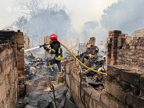 This handout photograph taken and released by Ukrainian State Emergency Service on July 9, 2025, shows a firefighter extinguishing a fire after a Russian attack in Zhytomyr region, amid the Russian invasion of Ukraine. 