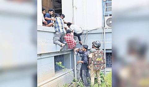 SFI workers help their comrades scale the Senate House campus wall in their attempt to enter the Kerala University’s headquarters during a protest against Governor Rajendra Arlekar, in Thiruvananthapuram on Tuesday 