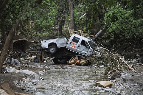 A damaged truck is seen on the banks of the river in Ruidoso, N.M. Wednesday, July 9, 2025, a day after major flooding washed away properties and Rv’s along the Rio Ruidoso Tuesday afternoon. 