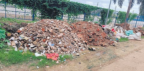 Heaps of construction waste lie along the canal road in White Field in Bengaluru