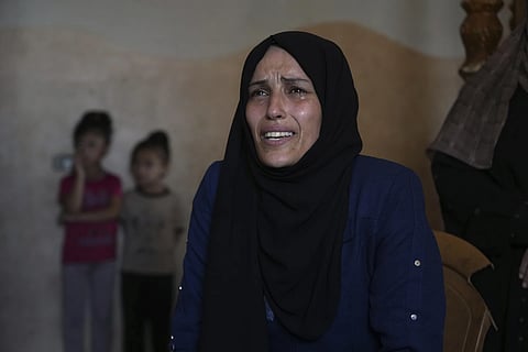 Iman Al-Nouri, the mother of two children who were killed, and one injured, in an Israeli strike while waiting to receive nutritional supplements at a medical clinic, reacts during an interview at her home in Deir al-Balah, Gaza Strip, Friday, July 11, 2025.