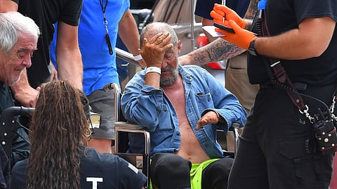Michael Pimentel, center, a resident at the Gabriel House assisted living facility, in Fall River, Mass., receives assistance from an emergency medical worker, right, outside a temporary shelter, Monday, July 14, 2025, in Fall River, following a fire that started late Sunday. 